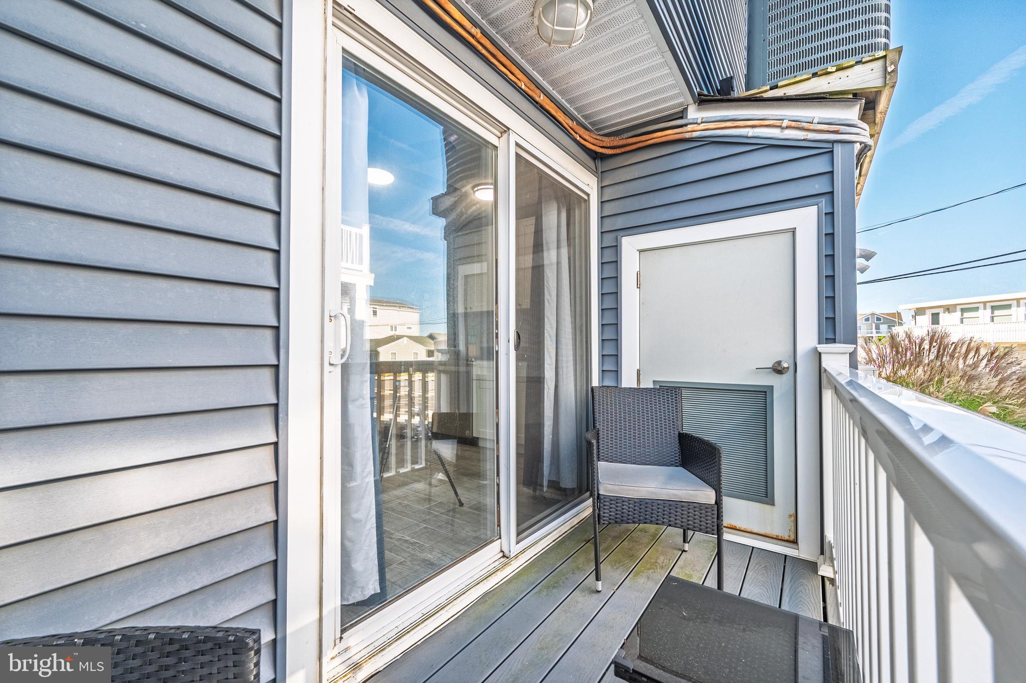 229 10th Street North, Unit 2 Brigantine, NJ 08203 - Photo 9 of 24 a balcony with view of dining room and wooden floor