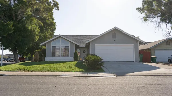 a front view of house with yard and garage