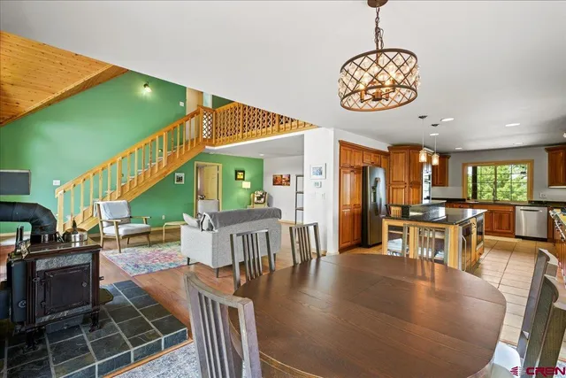 a dining room with wooden floor a chandelier a wooden table and chairs