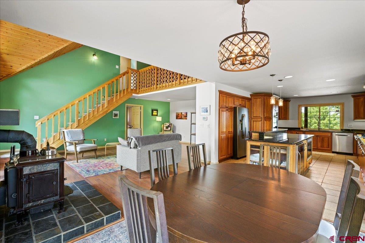 1010 Canyon Drive Ridgway, CO 81432 - Photo 11 of 38 a dining room with wooden floor a chandelier a wooden table and chairs