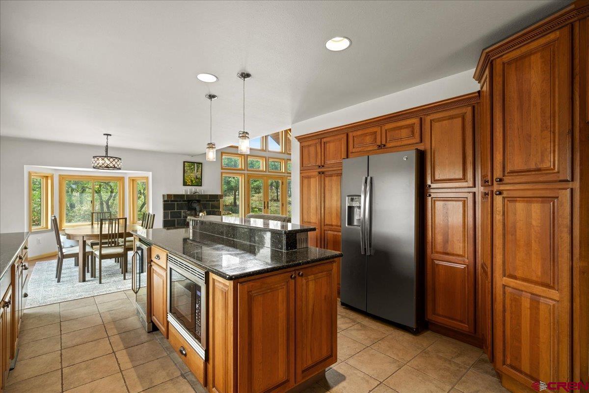 1010 Canyon Drive Ridgway, CO 81432 - Photo 12 of 37 a kitchen with stainless steel appliances granite countertop a refrigerator a stove a sink and a dining table