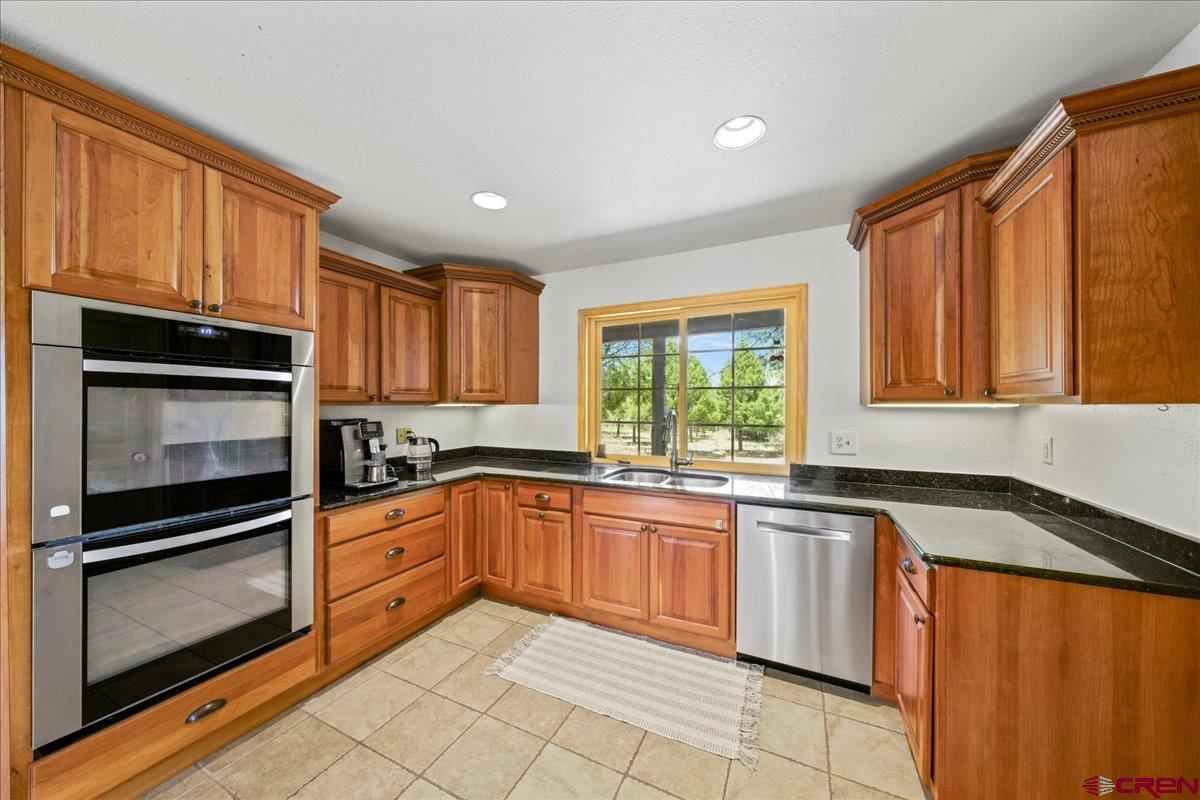 1010 Canyon Drive Ridgway, CO 81432 - Photo 14 of 37 a kitchen with granite countertop stainless steel appliances a stove sink and microwave