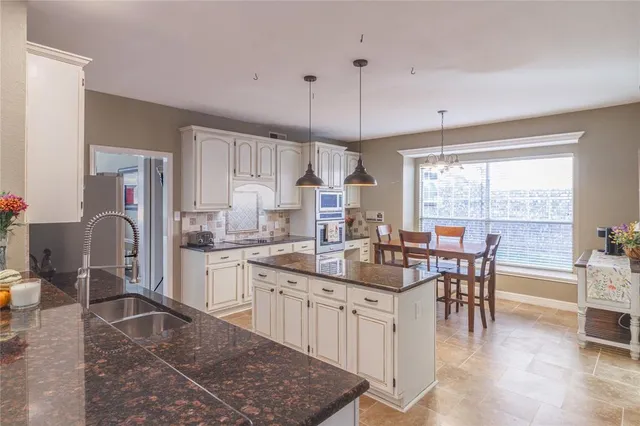 a kitchen with a sink stove cabinets and refrigerator