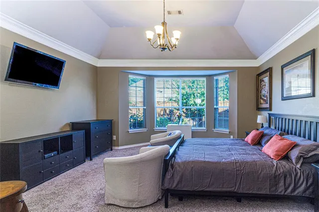 a bedroom with a bed and a chandelier