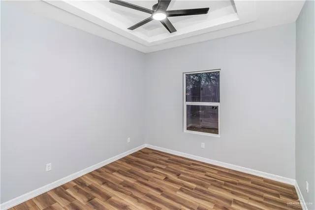 an empty room with a window and ceiling fan