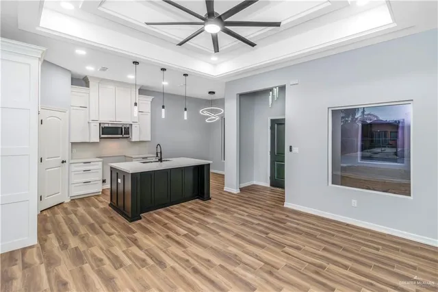 a large white kitchen with kitchen island a sink stainless steel appliances and cabinets