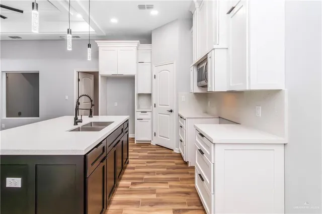 a kitchen with a sink and white cabinets