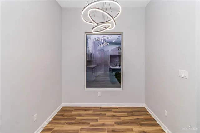 a view of a hallway with wooden floor and a white door