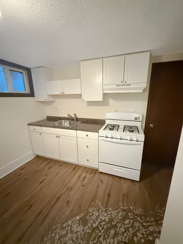 a kitchen with granite countertop white cabinets and white appliances