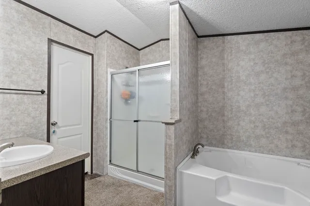 a bathroom with a granite countertop bathtub shower sink and vanity
