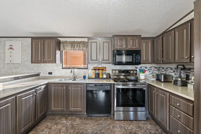 a kitchen with stainless steel appliances granite countertop a stove sink microwave and cabinets