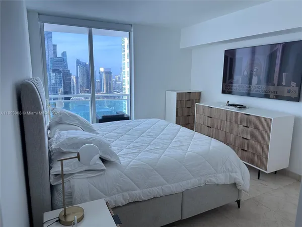 a bedroom with a bed and dresser with mirror