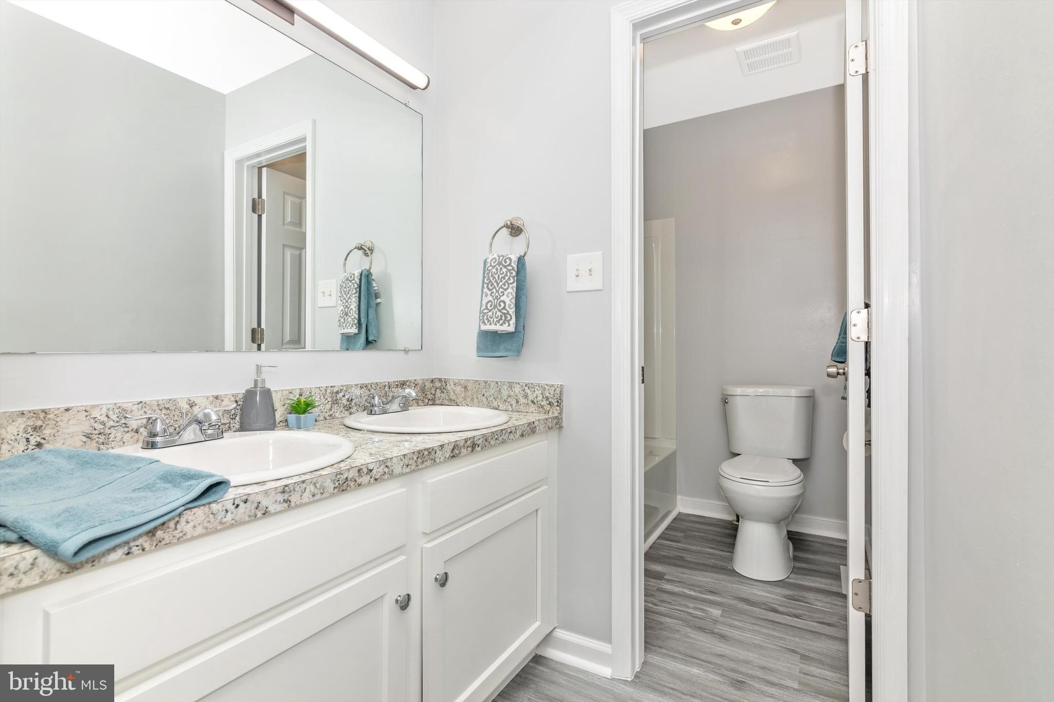 1702 Potomac Road Edgewater, MD 21037 - Photo 14 of 41 a bathroom with a granite countertop toilet sink and a mirror