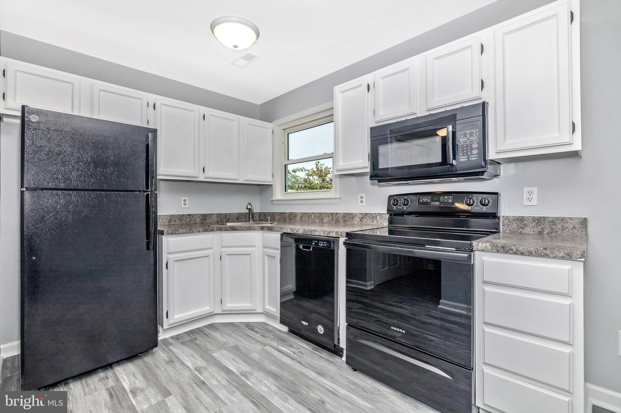 1702 Potomac Road Edgewater, MD 21037 - Photo 5 of 41 a kitchen with granite countertop a refrigerator stove and microwave