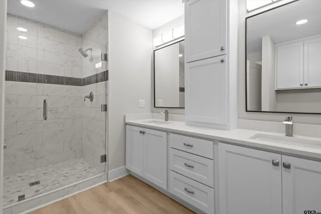 a bathroom with a double vanity sink mirror and shower