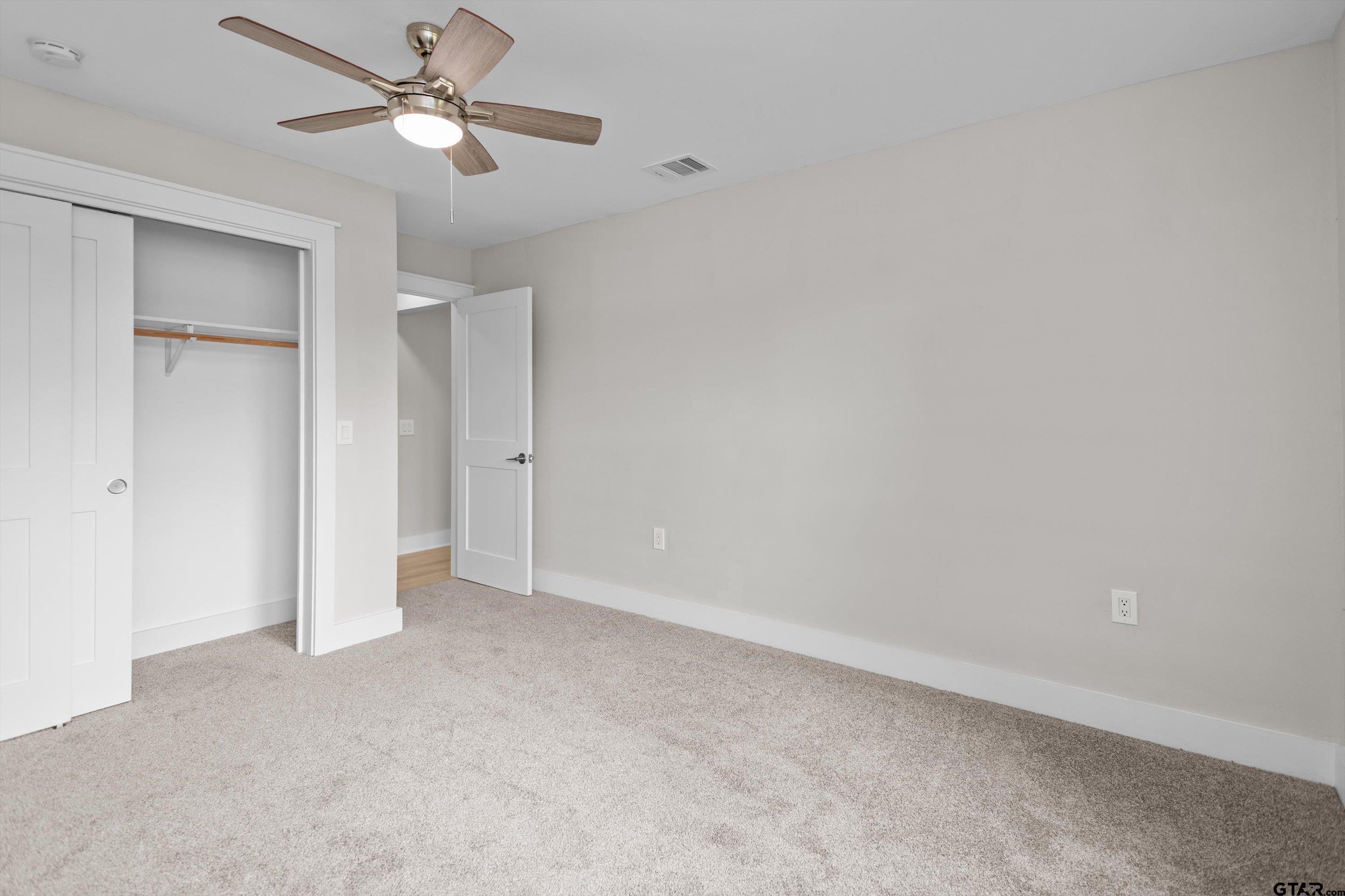 601 North 4th Street Crockett, TX 75835 - Photo 12 of 25 an empty room with a ceiling fan and a fan