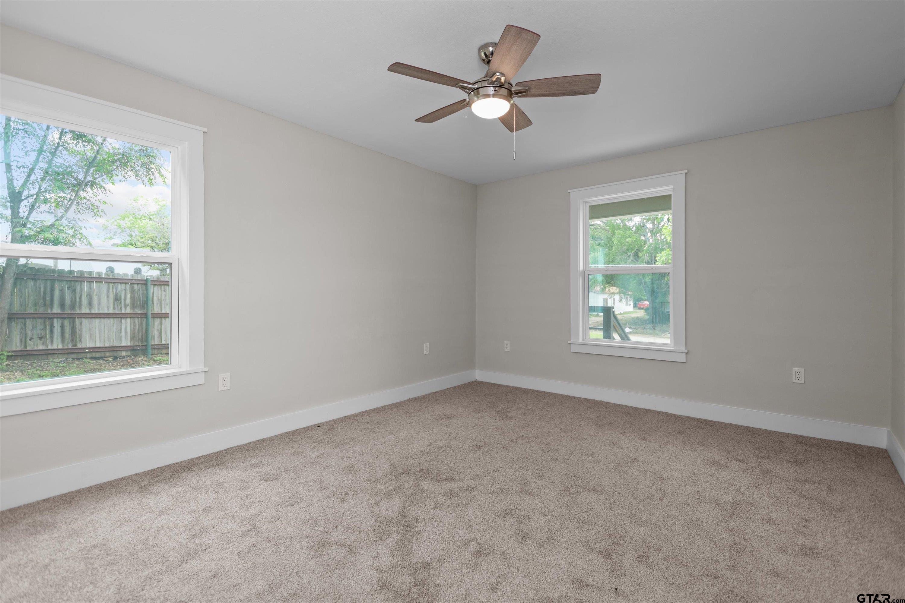 601 North 4th Street Crockett, TX 75835 - Photo 15 of 25 an empty room with windows and ceiling fan