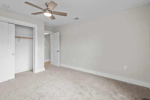 an empty room with a ceiling fan and a fan