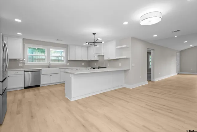 a large kitchen with kitchen island a sink stainless steel appliances and cabinets