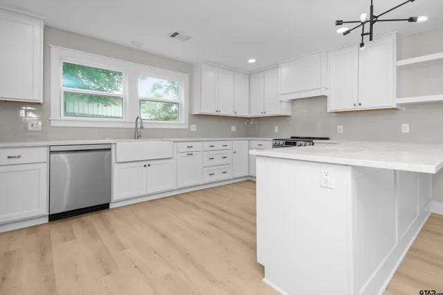a kitchen with cabinets a sink and appliances