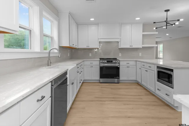 a kitchen with a sink stove top oven and cabinets