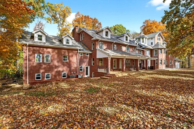 a view of staircase with lots of frames on wall and wooden floor