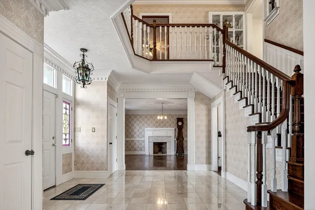 a view of an empty room with wooden floor fireplace and a window