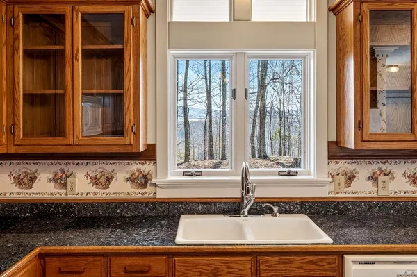 an empty room with wooden floor chandelier fan and windows