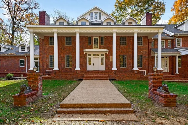 front view of a brick house with a yard