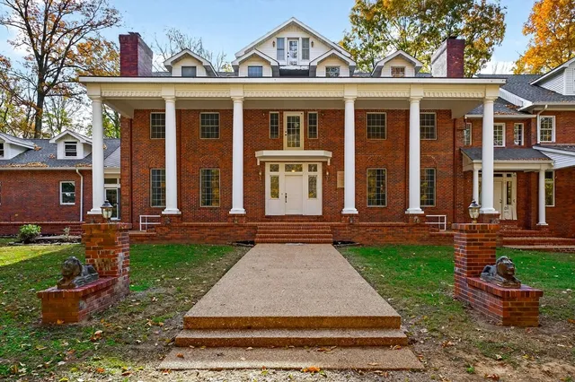 front view of a brick house with a yard