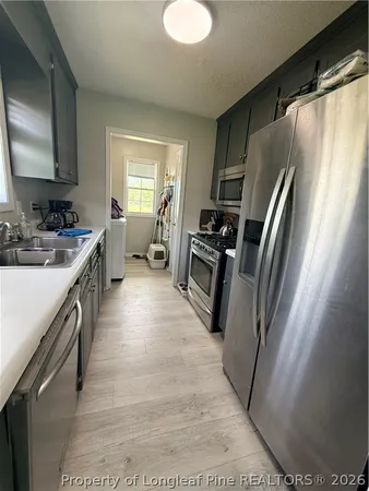 a kitchen with sink a refrigerator and a stove