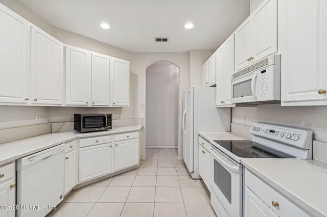 a kitchen with white cabinets and white appliances