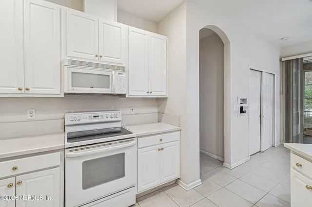 a view of a hallway with a white cabinet and a mirror