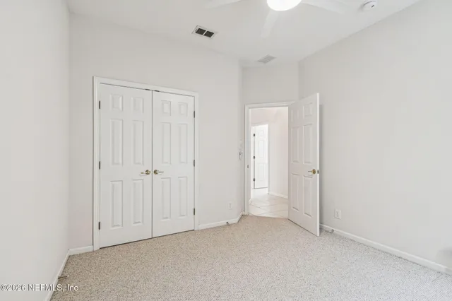 an empty room with an entryway and fan