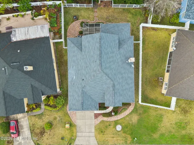 a view of a swimming pool with a yard and palm trees
