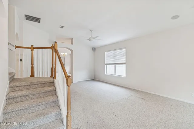an empty room with staircase and white walls
