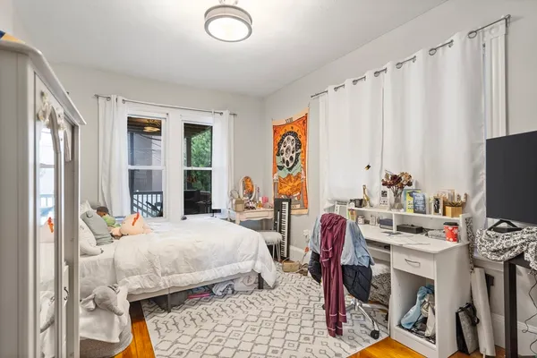 a bedroom with bed a flat tv screen and a window