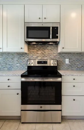 a bathroom with a granite countertop sink mirror vanity and toilet