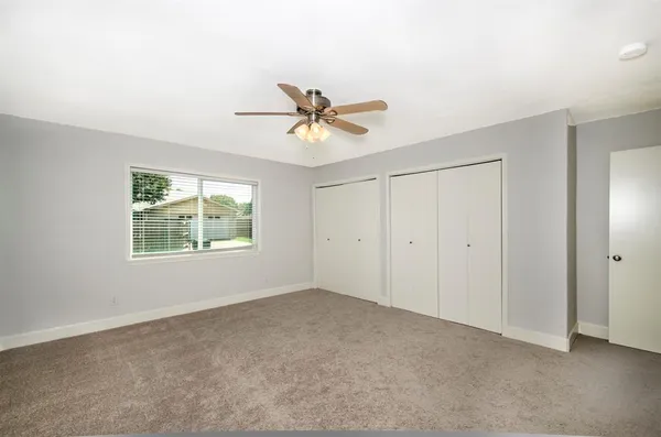 a view of an empty room with a chandelier fan