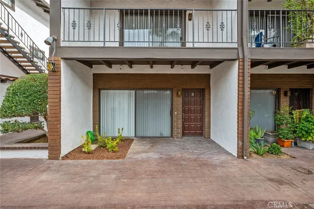 a view of a brick house with large windows and a table