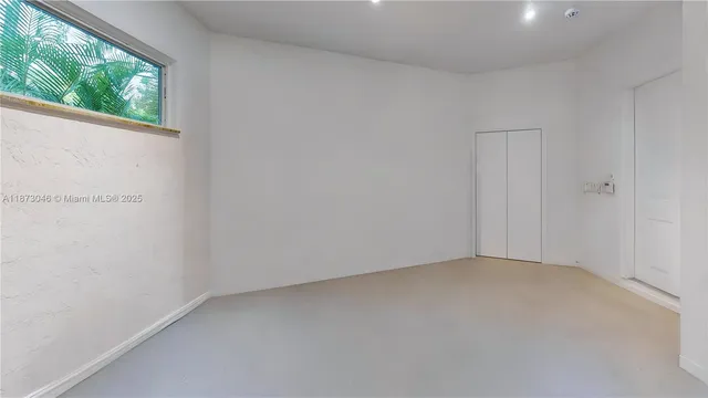 a view of an empty room with wooden floor and windows