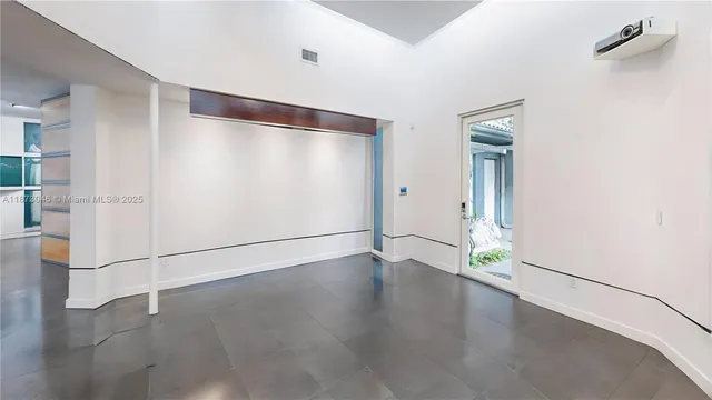 a view of an empty room with a window and workspace