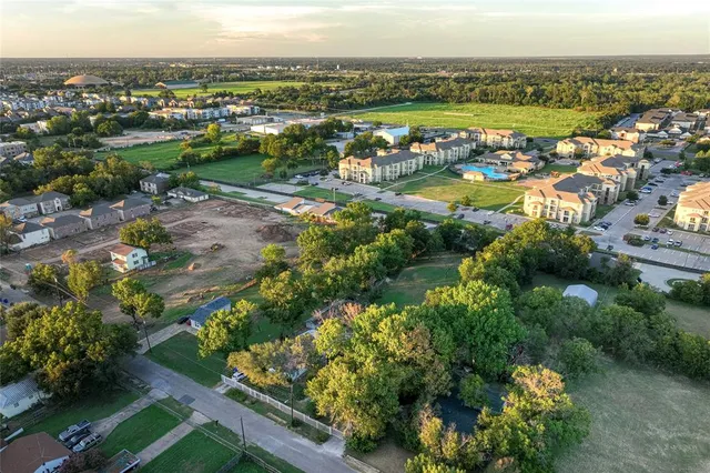 an aerial view of a city with lots of residential buildings and mountain view in back
