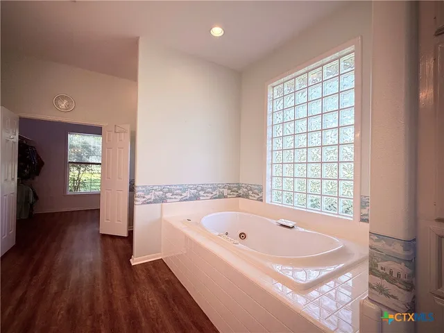 a bathroom with a bathtub and a window