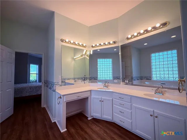 a spacious bathroom with a double vanity sink a large mirror and a bathtub