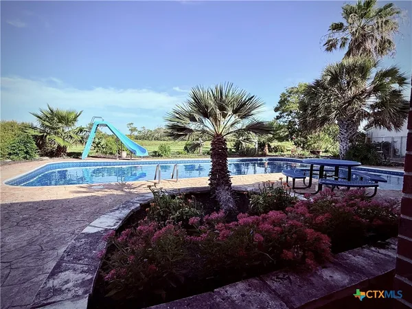 a view of a house with a yard and potted plants