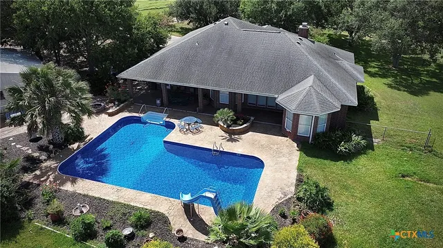 a view of a house with pool and chairs