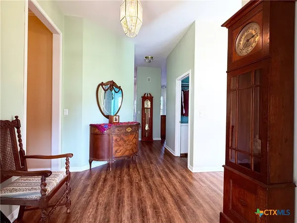 a view of a hallway with wooden floor and furniture