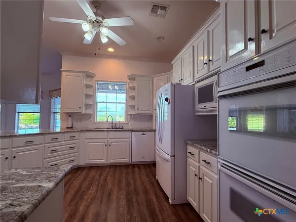 a kitchen with stainless steel appliances granite countertop a stove a sink dishwasher and a refrigerator