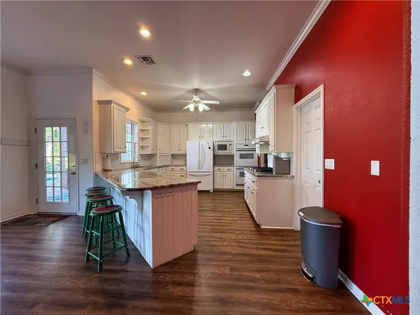 a kitchen with a dining table chairs and kitchen